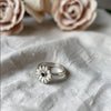 Silver ring with a black gemstone on a white fabric background