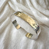 Silver cuff bracelet on a white fabric background