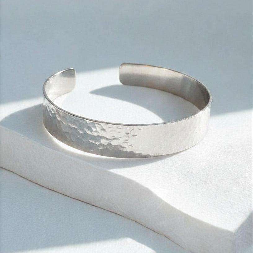 Silver bracelet on a light gray surface