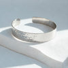Silver bracelet on a light gray surface