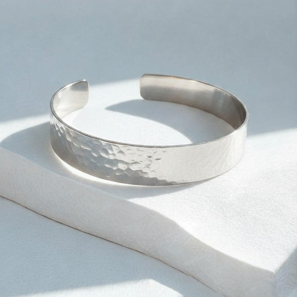 Silver bracelet on a light gray surface