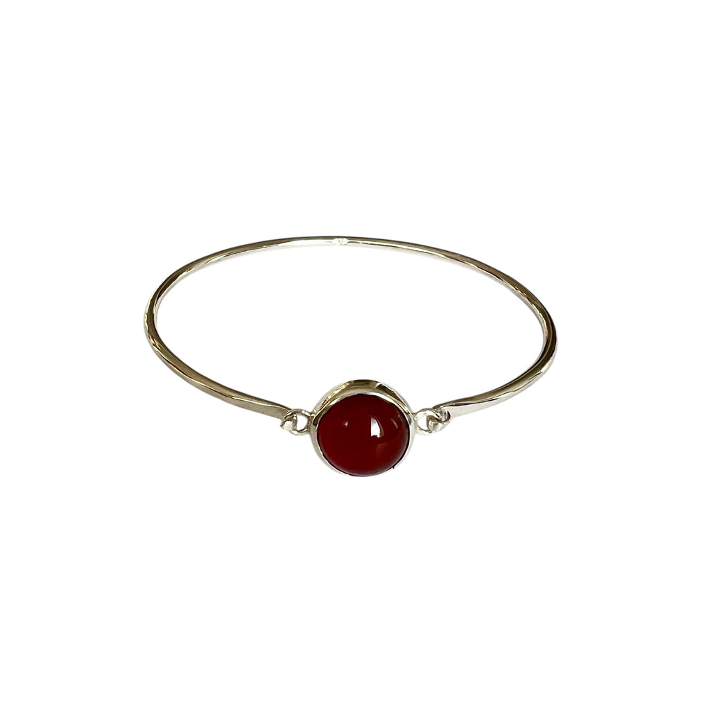 Silver bracelet with red carnelian stone on white background