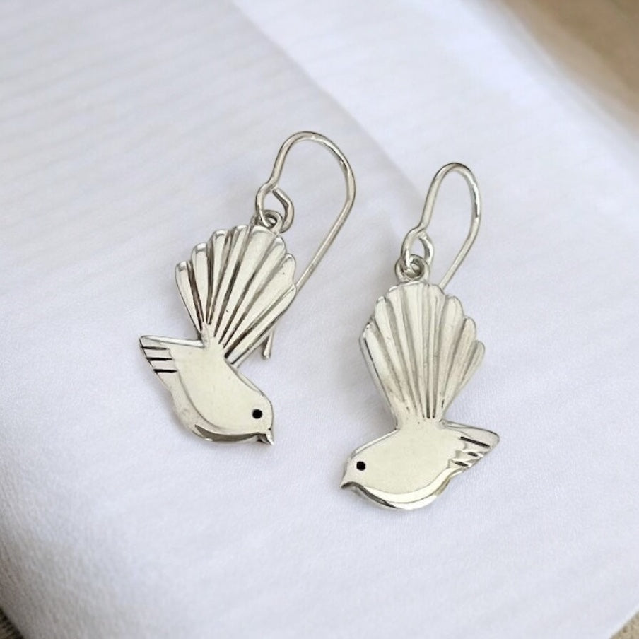 Silver bird-shaped earrings on a white background