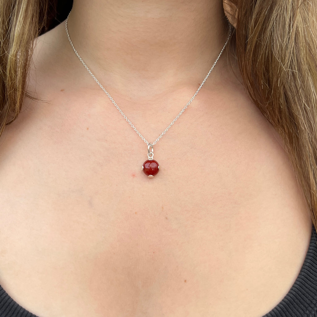 Necklace with a red pendant worn by a person