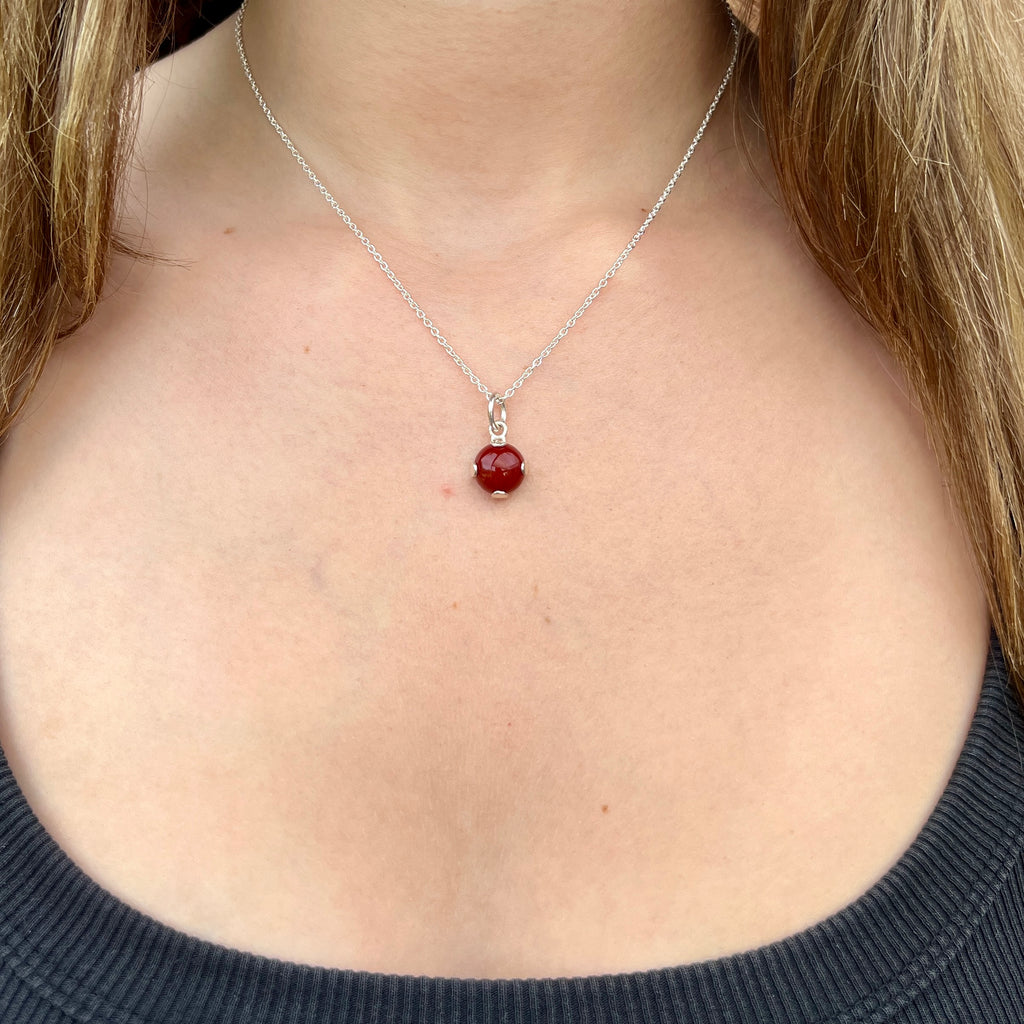Necklace with a red pendant worn by a person