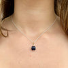 Necklace with a dark blue pendant on a person's neck
