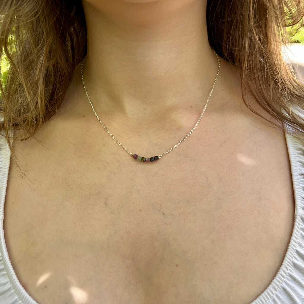 Necklace with small beads worn by a person outdoors