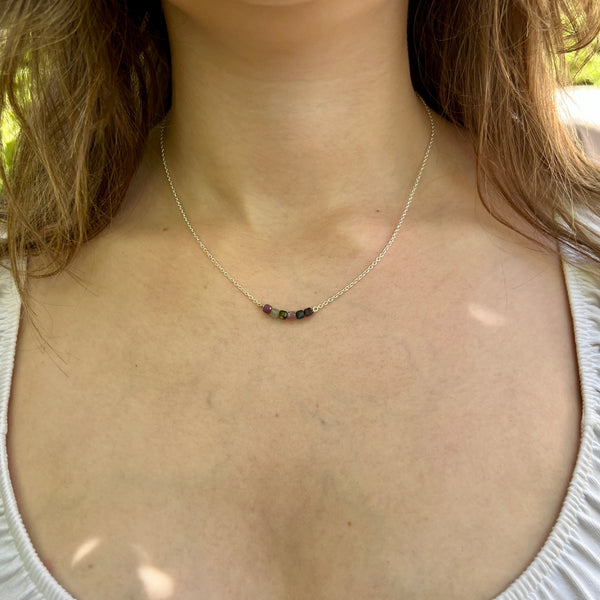 Necklace with small beads worn by a person outdoors