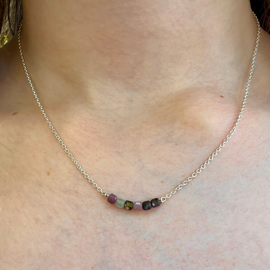 Necklace with small beads on a person's neck