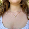 Gold necklace with a butterfly pendant worn by a person