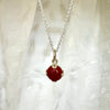 Red gemstone necklace against white fabric