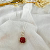 Red gemstone necklace against white fabric