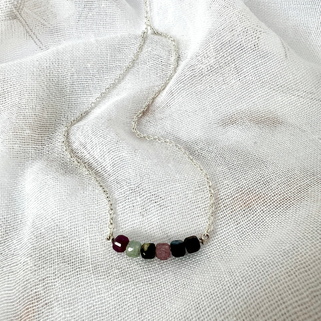 Necklace with small beads on a white fabric background