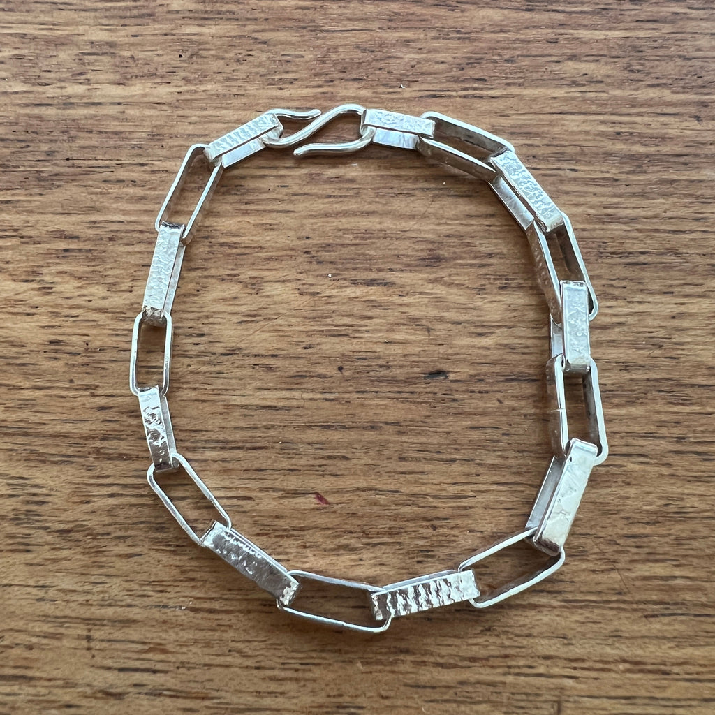 Silver chain bracelet on a wooden surface