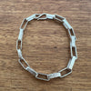 Silver chain bracelet on a wooden surface