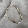 Silver bracelet on a textured gray fabric background
