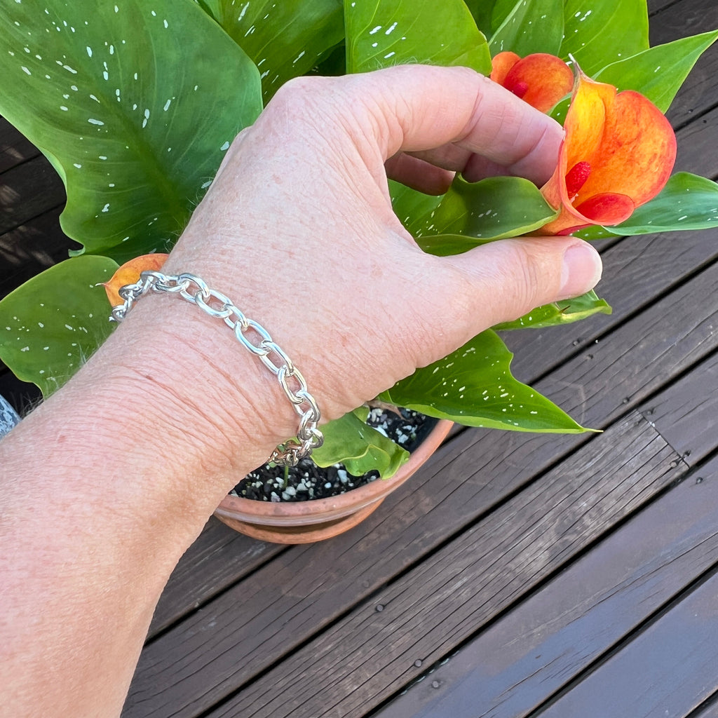 Hand holding a small orange plant against a wooden background