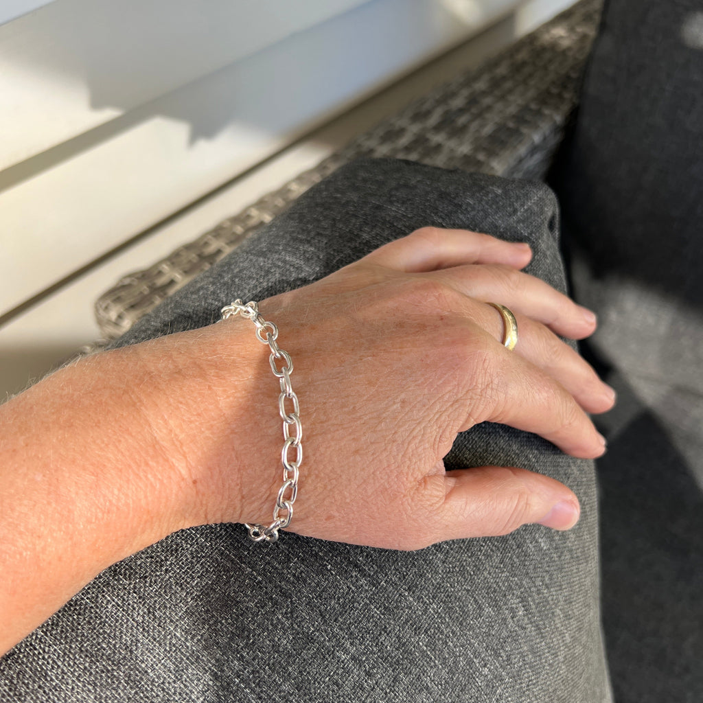 Hand with a ring and bracelet on a textured surface