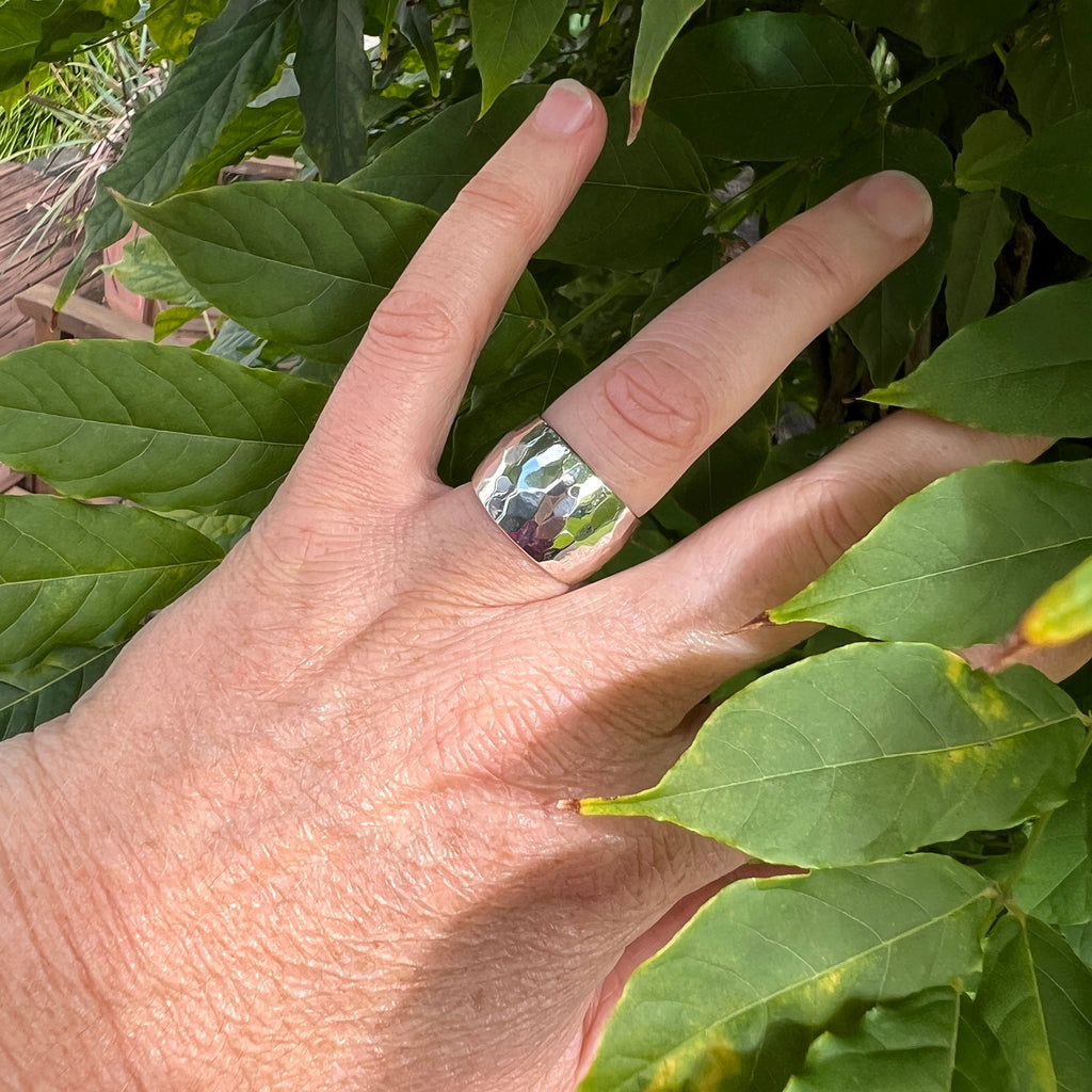 Hand with a ring on a leafy background