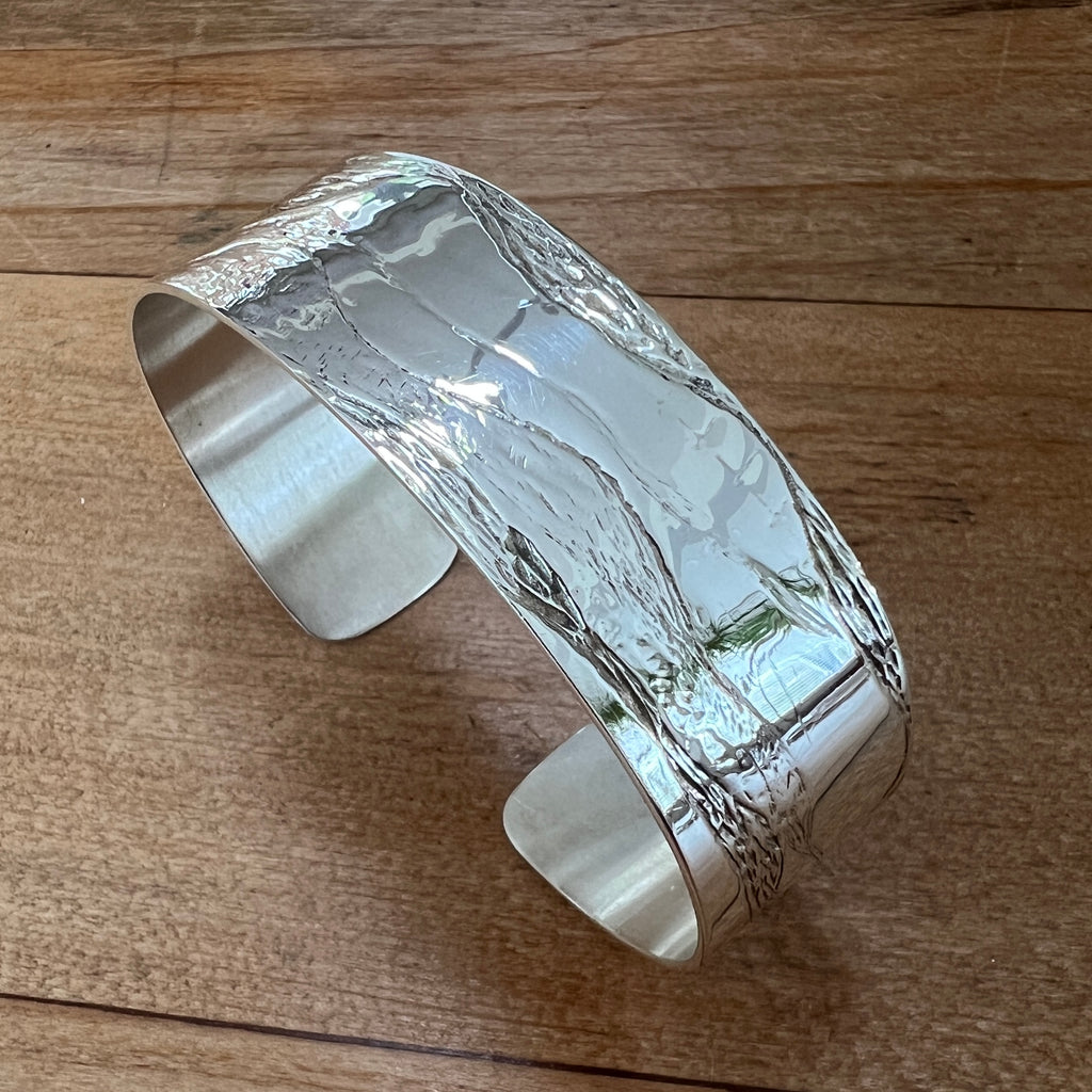 Silver cuff bracelet on a wooden surface