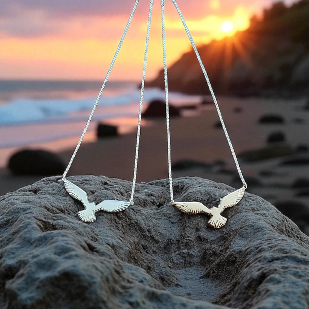 Necklace with bird pendants on a rock at sunset