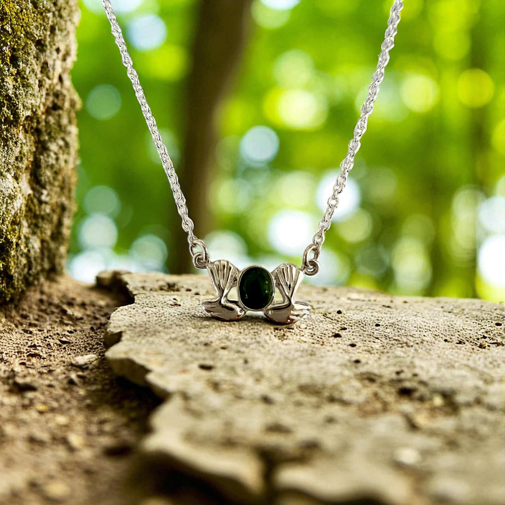 Silver necklace with a pendant on a rock in a forest setting