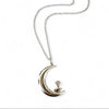 Silver necklace with a crescent moon and bird pendant on a white background