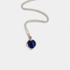 Silver necklace with a blue gemstone pendant on a white background