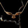 Gold Cooks petrel pendant on a black background